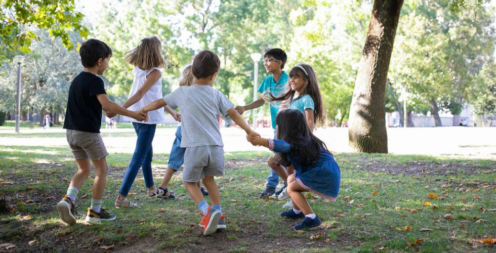 happy-children-playing-together-outdoors-dancing-around-on-grass-enjoying-outdoor-activities-and-having-fun-in-park-kids-party-or-friendship-concept_Easy-Resize.com